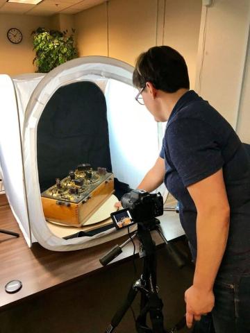 Person taking photograph of a physical object to digitize and document