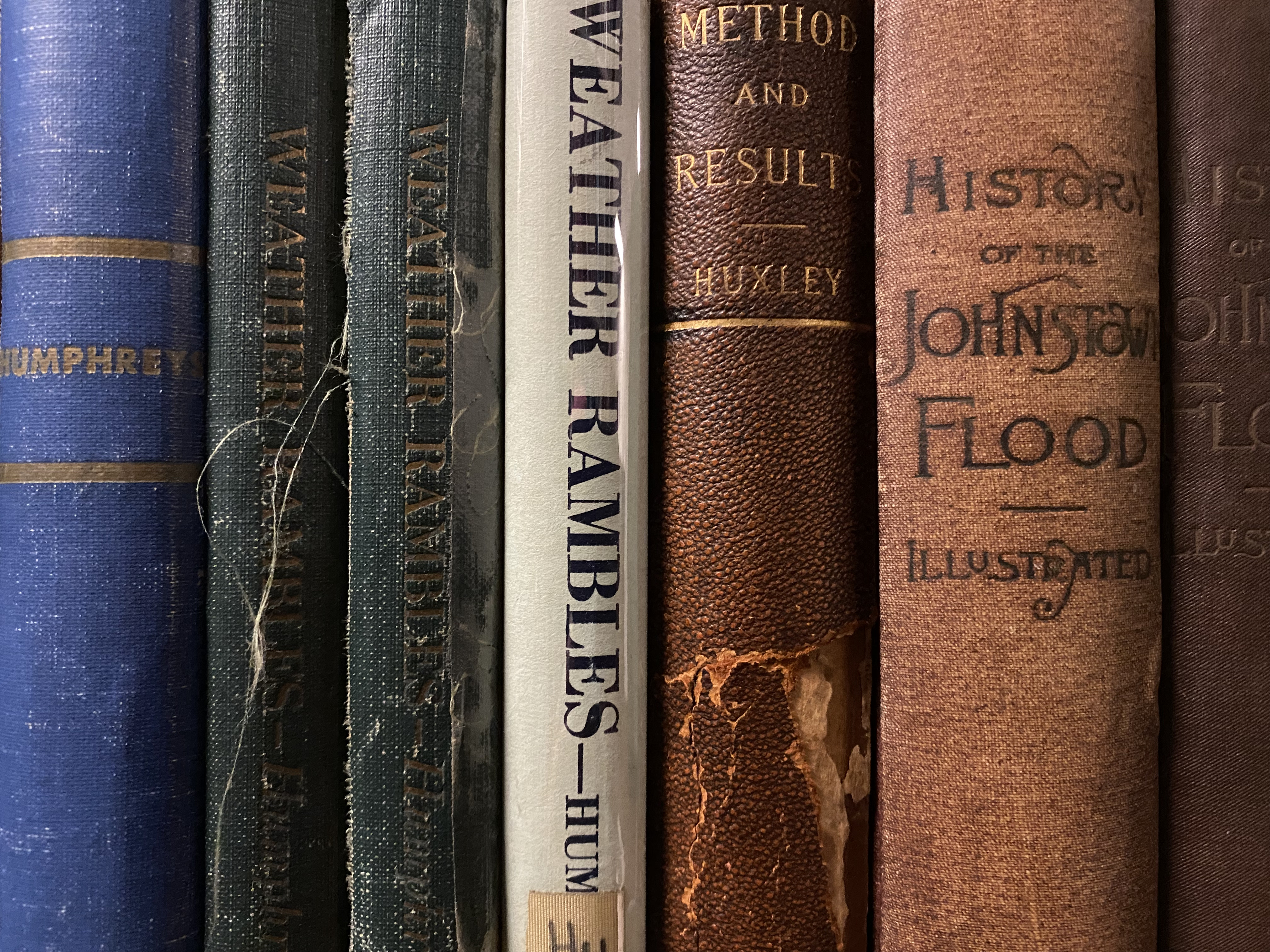 Photo of shelf of books with spines visible (10th and 19th century volumes)