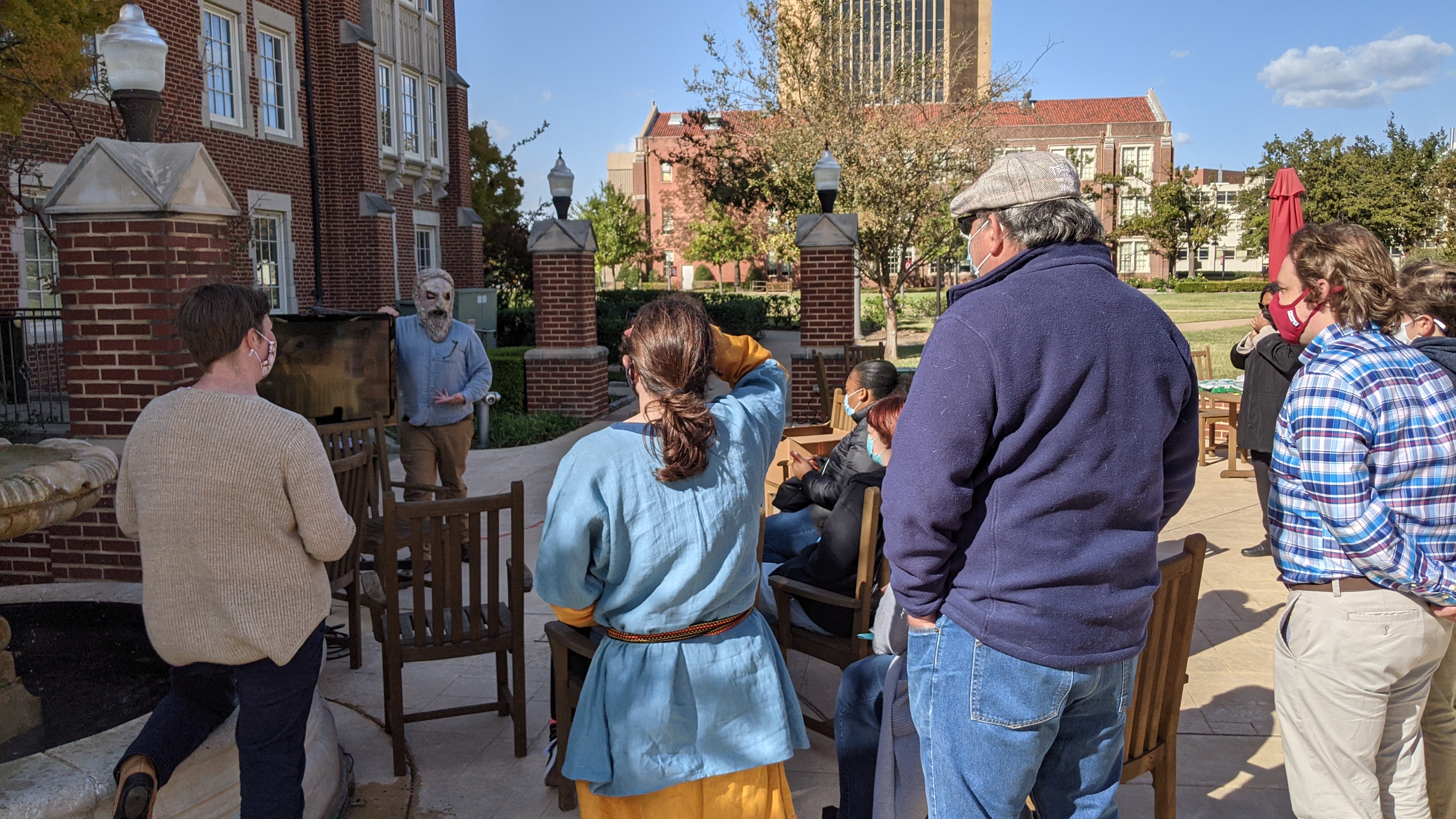 group gathered outside watching a TV