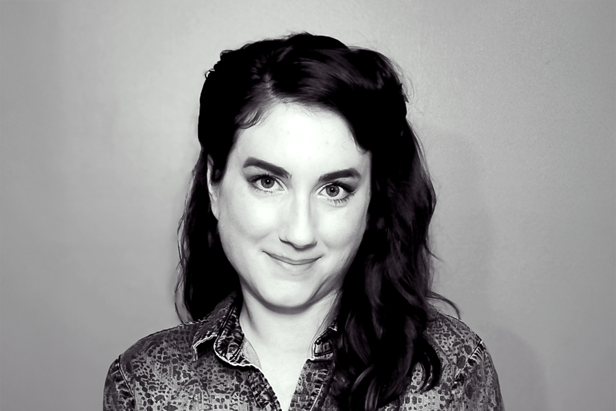 Black and white headshot of Colleen Cressman. She has dark, wavy hair, is wearing a patterned blouse, and smiles softly at the camera.