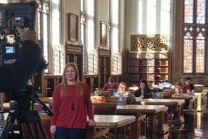 A photo of a student being filmed in the great reading room