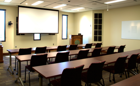 Harlow Room showing chairs, tables, and a projector screen.