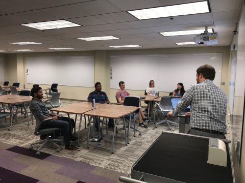 A large study room with students sitting around tables