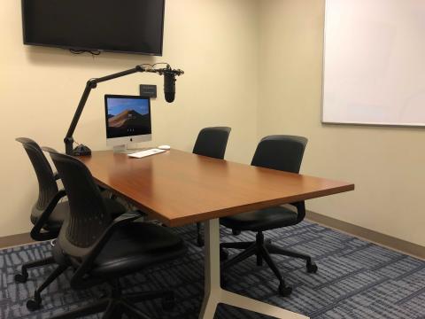 Room with chairs, computer, and microphone.