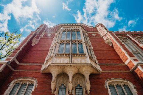 Bizzell Library low angle shot looking up at the beautiful architecture of red brick facade and ornate windows.